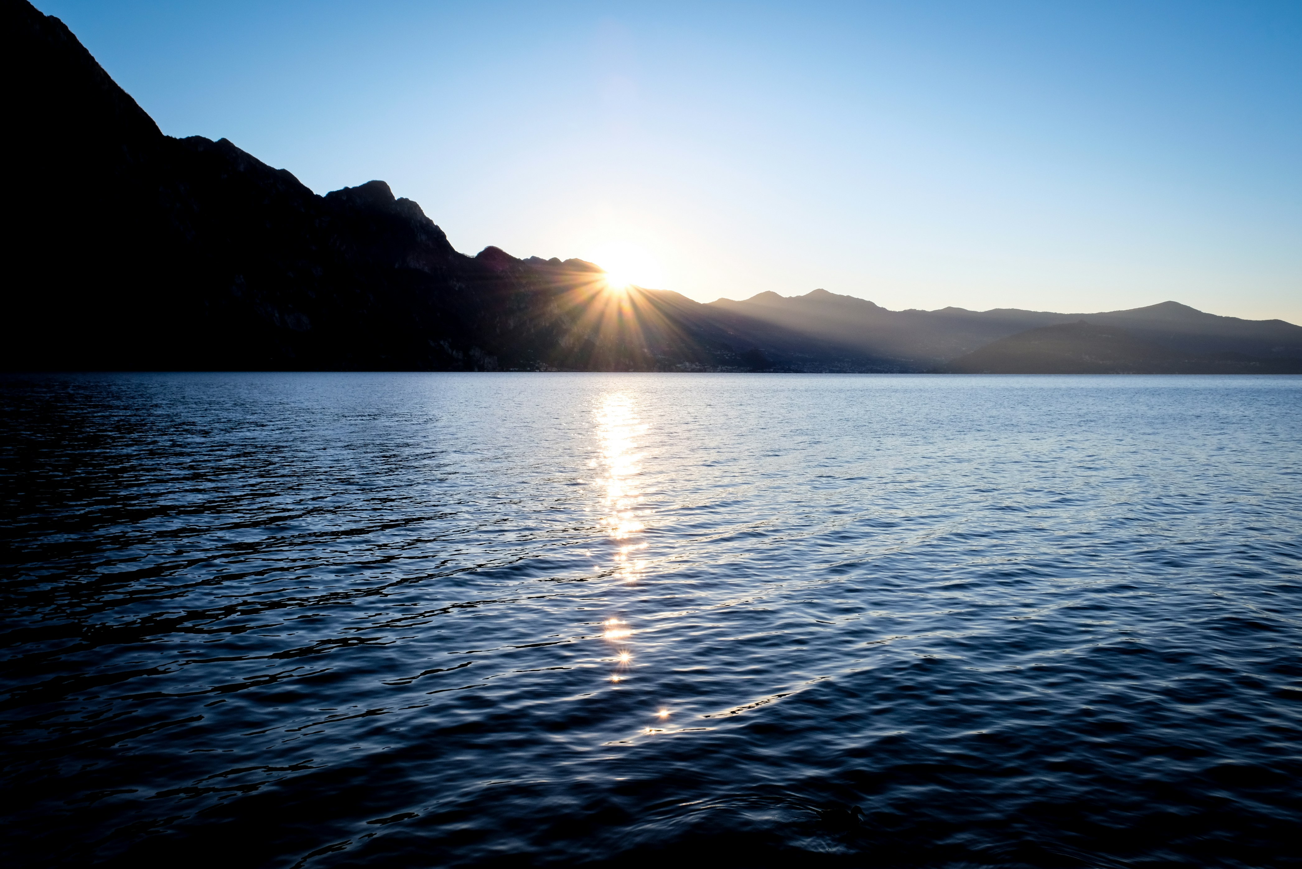 calm body of water under blue sky during daytime